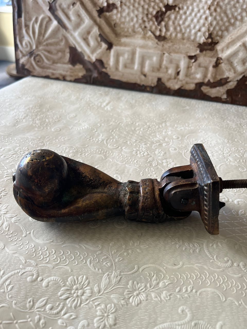 "Antique French cast iron 'Hand of Fatima' door knocker with a decorative ruffled cuff, holding a ball, can mounted on a rustic wooden door. or modern door"